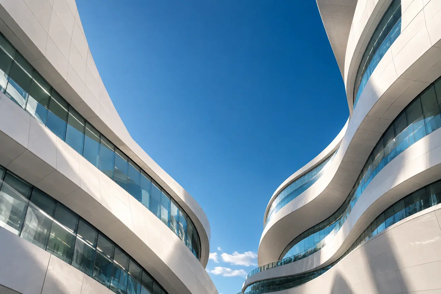 Sweeping contemporary architecture opening onto a clear blue sky